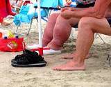 photo of woman sitting on the beach suffering with edema an effect of too much sodium