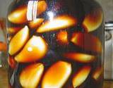 photo of a canning jar filled with garlic cloves soaking in vinegar with emphasis on the benefits of garlic