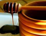 a photo of black strap molasses in a wooden pot a natural source to prevent iron deficiency