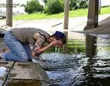 photo of a woman drinking water from water under a bridge in need of a parasite cleanse