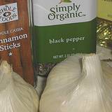 photo of bulbs of garlic with a can of black pepper and cinnamon sticks with emphasis on the benefits of garlic