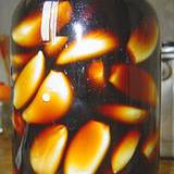 photo of a canning jar filled with garlic cloves soaking in vinegar with emphasis on the benefits of garlic